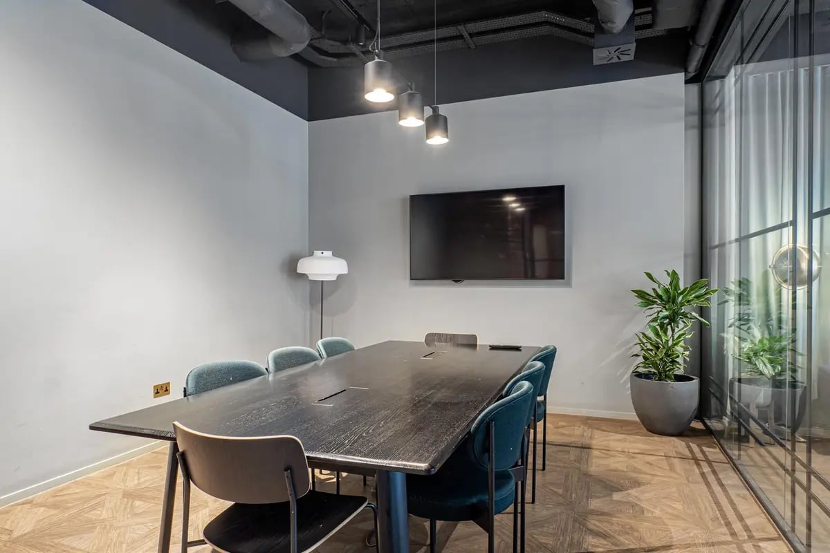 Large table with chairs and TV meeting room at Chapter Old Street in London Student Accommodation