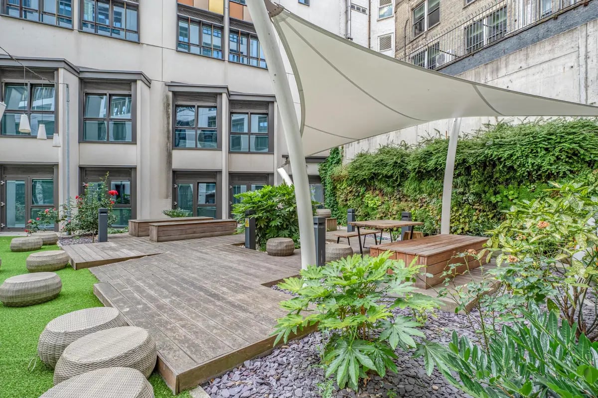 Wooden deck with benches under canopy exterior at Chapter Old Street in London Student Accommodation