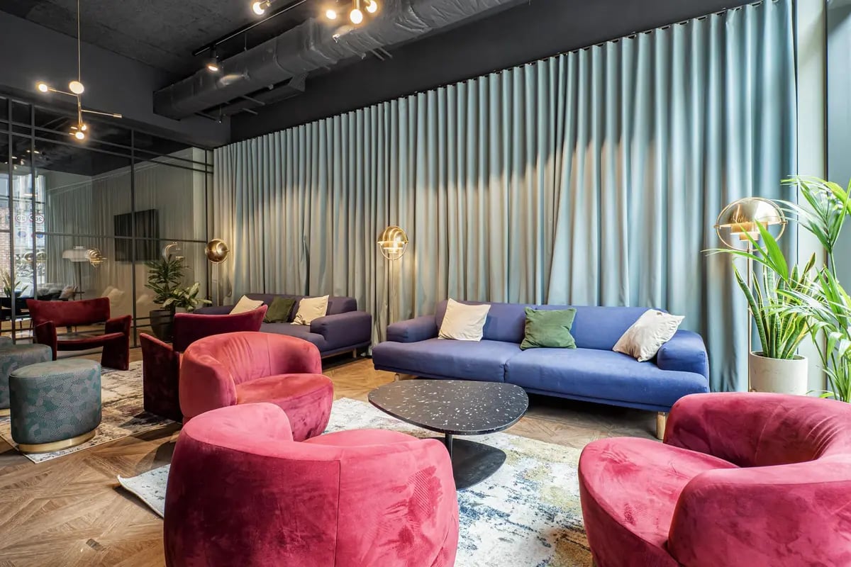 Purple sofas plush chairs modern table living area at Chapter Old Street in London Student Accommodation
