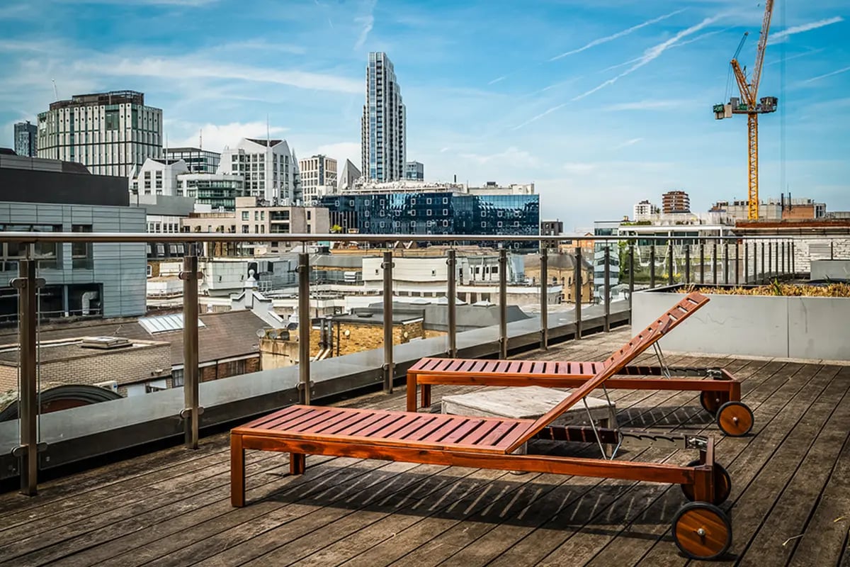 Wooden lounge chairs on rooftop exterior at Chapter Old Street in London Student Accommodation