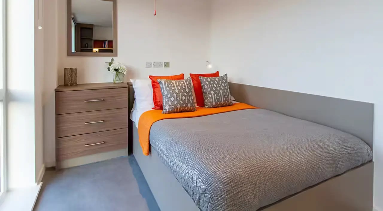 Bed dresser mirror window and pillows bedroom at Dean Street Works in Bristol Student Accommodation