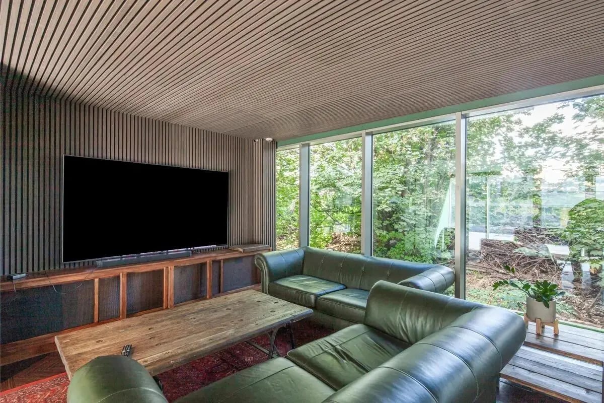 Green sofas large television wooden table living room at Chapter Lewisham in London Student Accommodation