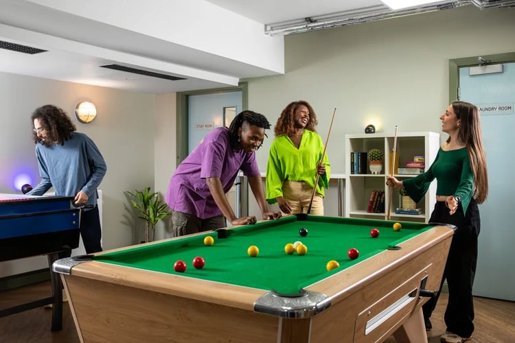 Students playing pool and foosball game area at Student Living Heights in London Student Accommodation