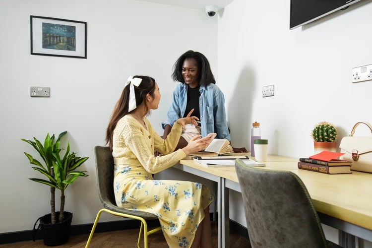Two students studying at desk with books living room at Student Living Heights in London Student Accommodation