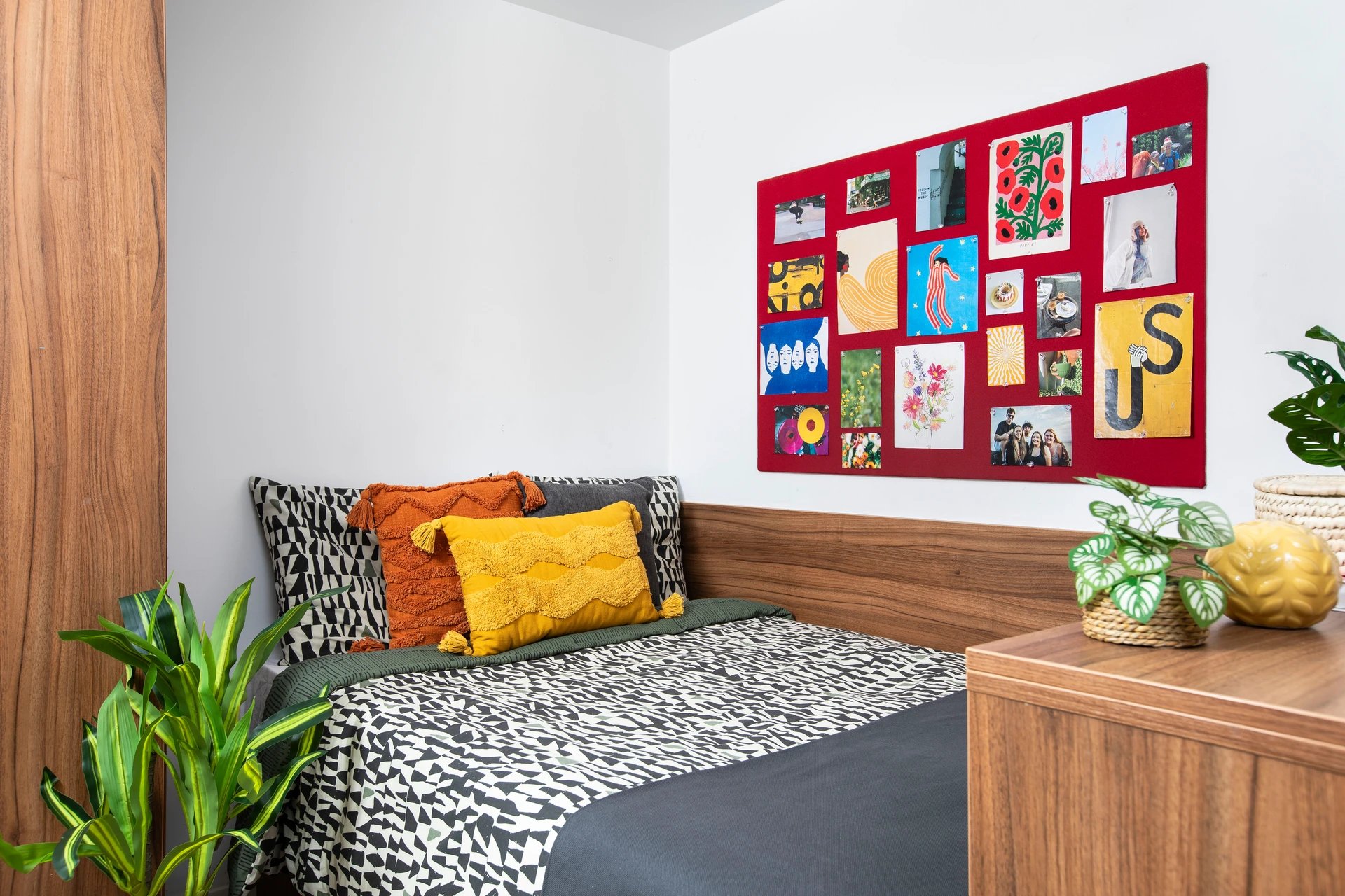 Bed with patterned pillows and collage bedroom at Student Living Heights in London Student Accommodation