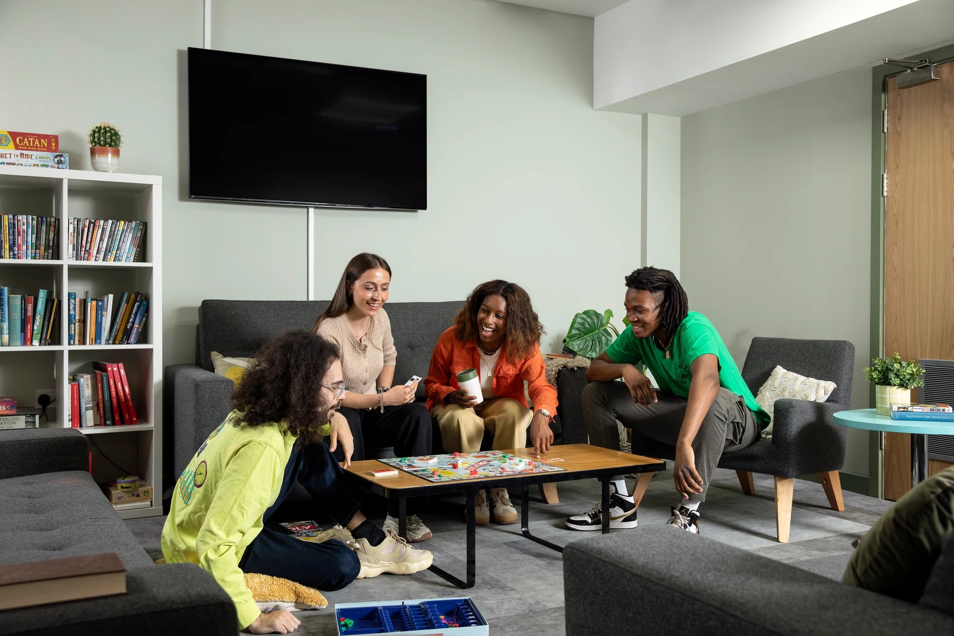 Students playing board game in lounge living room at Student Living Heights in London Student Accommodation