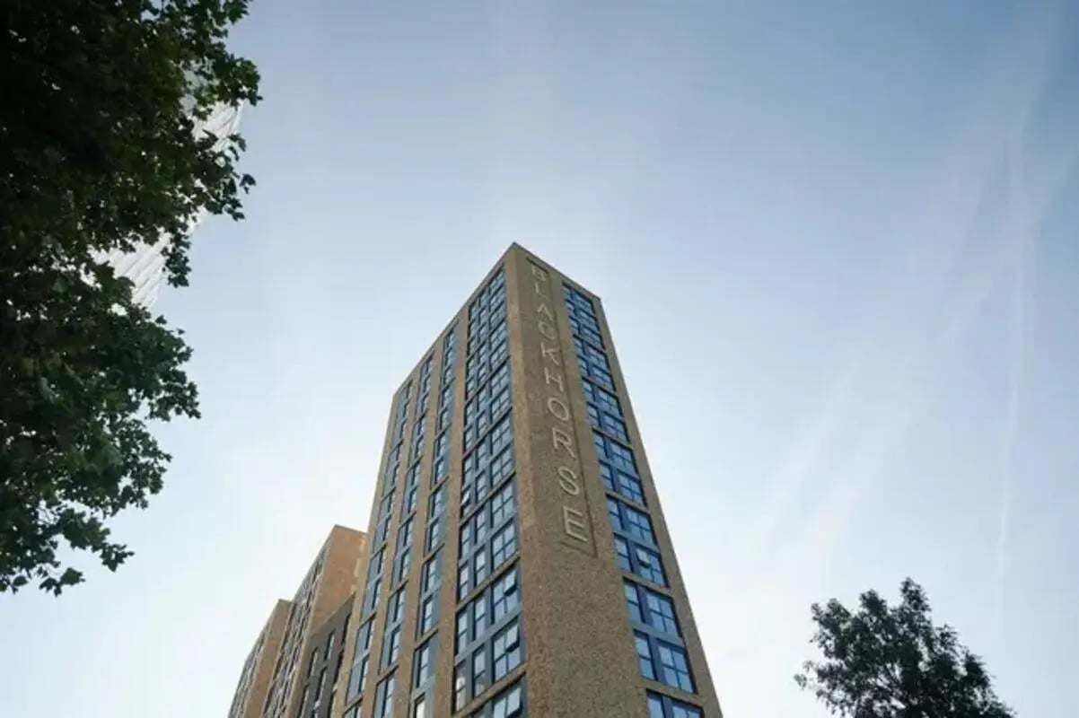 Tall brick building with BLACKHORSE text Exterior at Canvas Walthamstow in London Student Accommodation