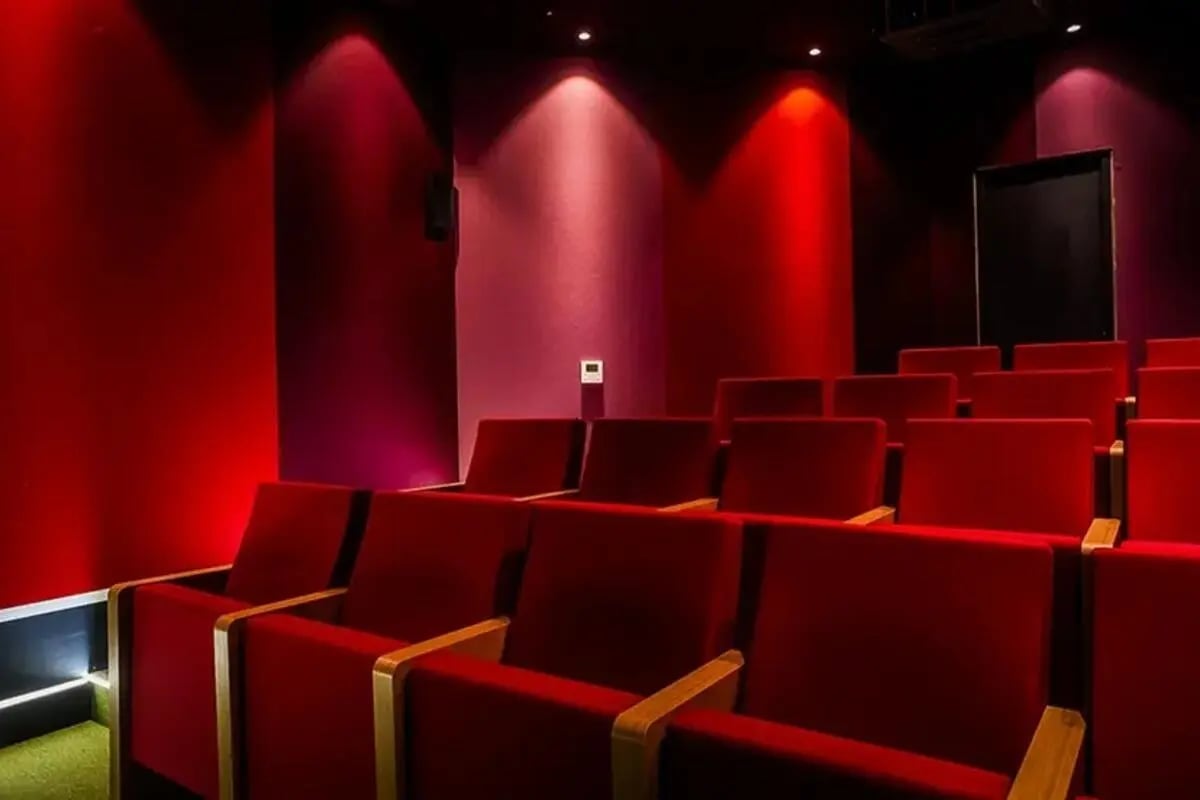 Red cinema seating with wooden armrests and projector cinema at Chapter Highbury in London Student Accommodation