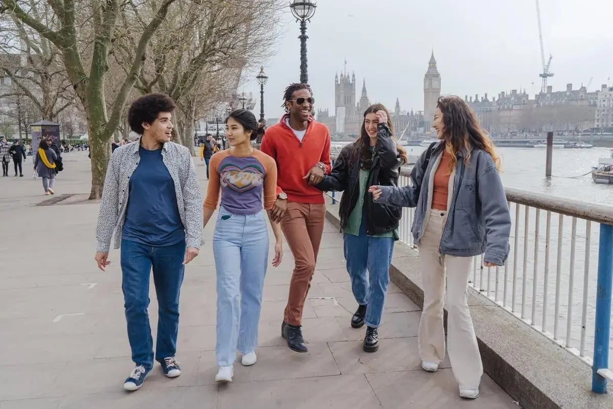 Five students walk along the Thames exterior at Chapter Westminster in London Student Accommodation