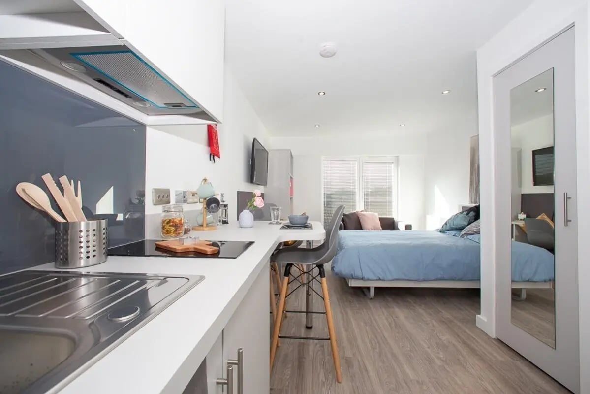 Kitchenette and bed with blue bedding living room at The Laceworks Nottingham in Nottingham Student Accommodation