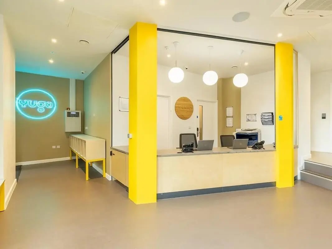 Reception desk with laptops printer and signage reception area at Yugo Goldsmith Court in Nottingham Student Accommodation