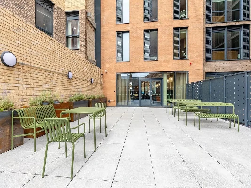 Green outdoor seating and tables exterior area at Fabric in Nottingham Student Accommodation
