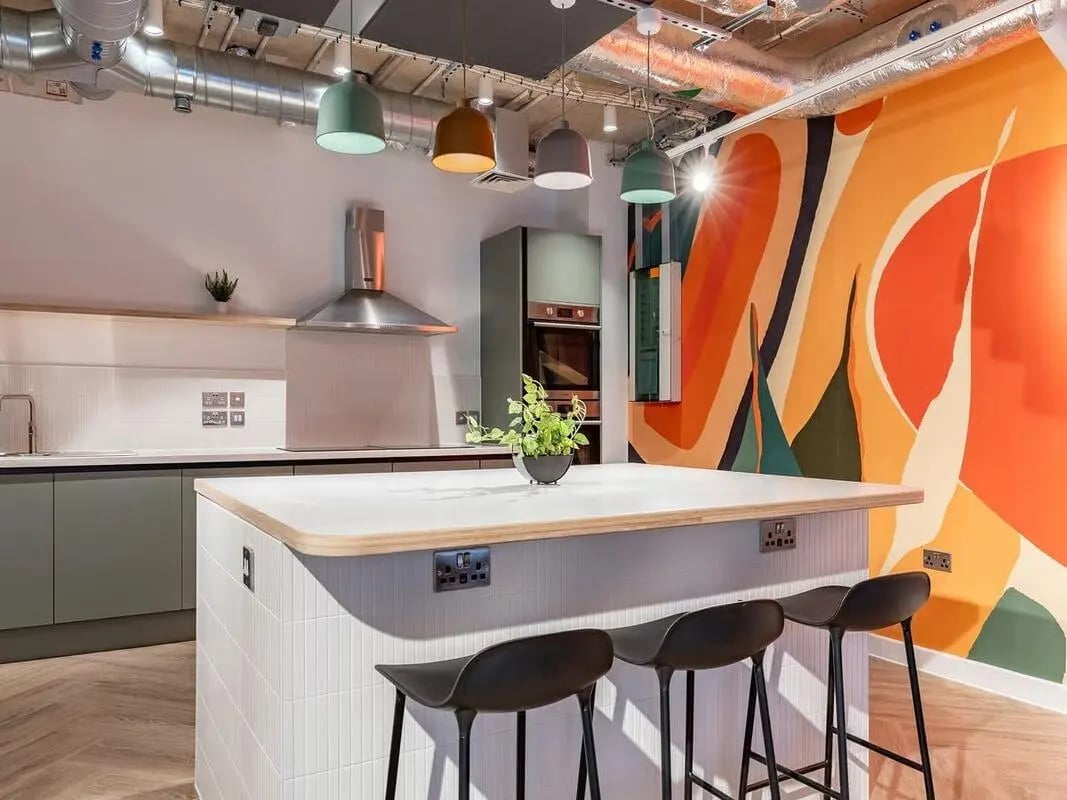 Modern kitchen island with stools and bold mural kitchen at Fabric in Nottingham Student Accommodation
