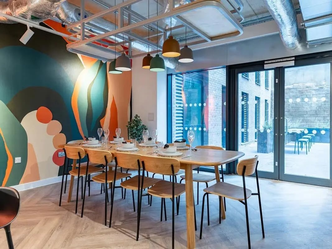 Dining table with place settings and chairs communal area at Fabric in Nottingham Student Accommodation