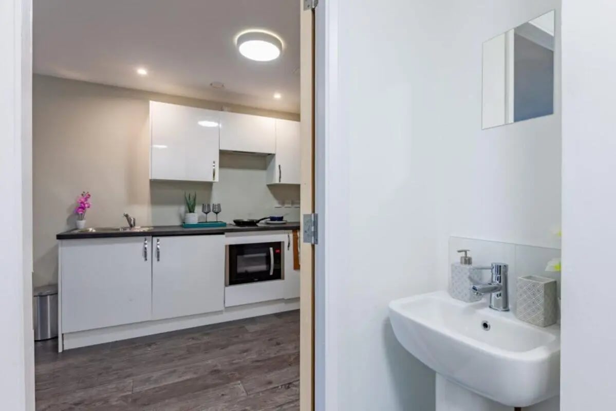 White cabinets sink microwave kitchen area and bathroom sink at One Islington Plaza in Liverpool Student Accommodation