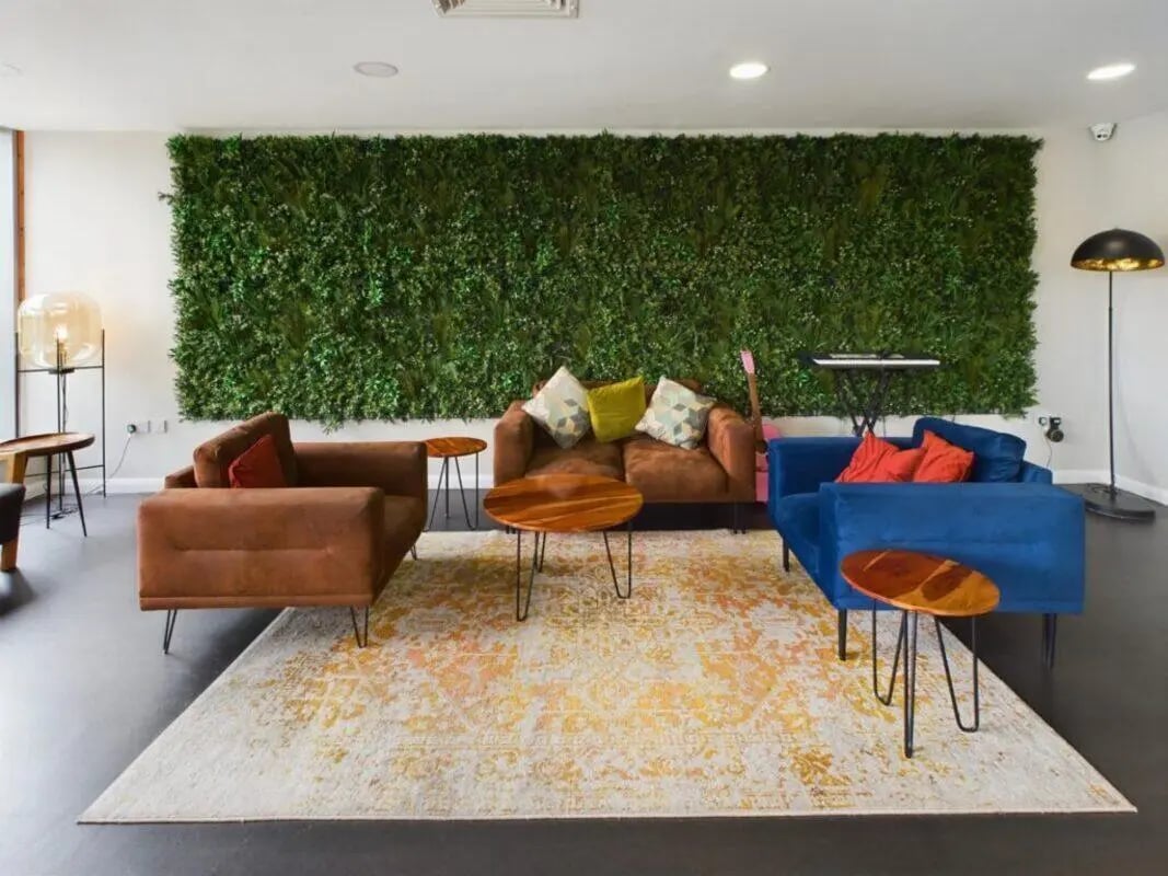 Sofa chairs rug plants keyboard guitar living room at One Islington Plaza in Liverpool Student Accommodation