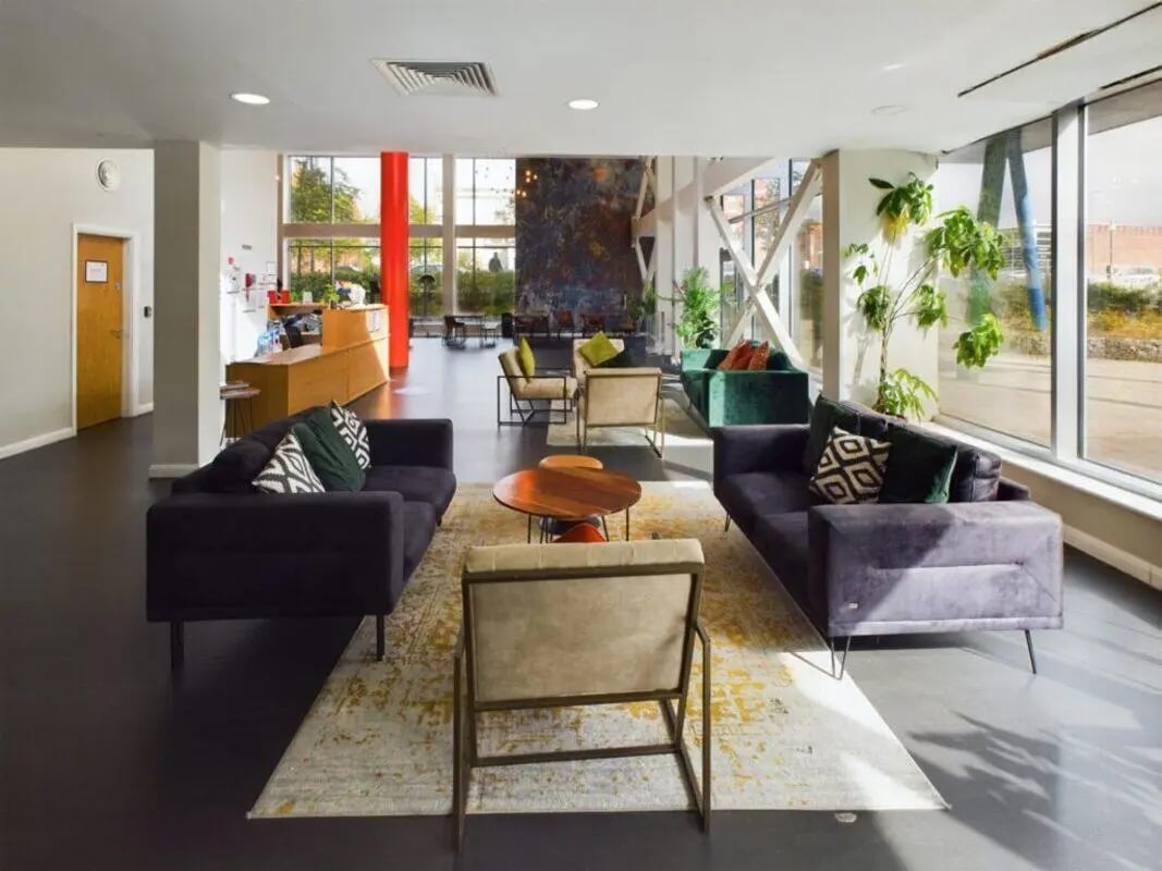 Sofas chairs tables rug and plants common area at One Islington Plaza in Liverpool Student Accommodation