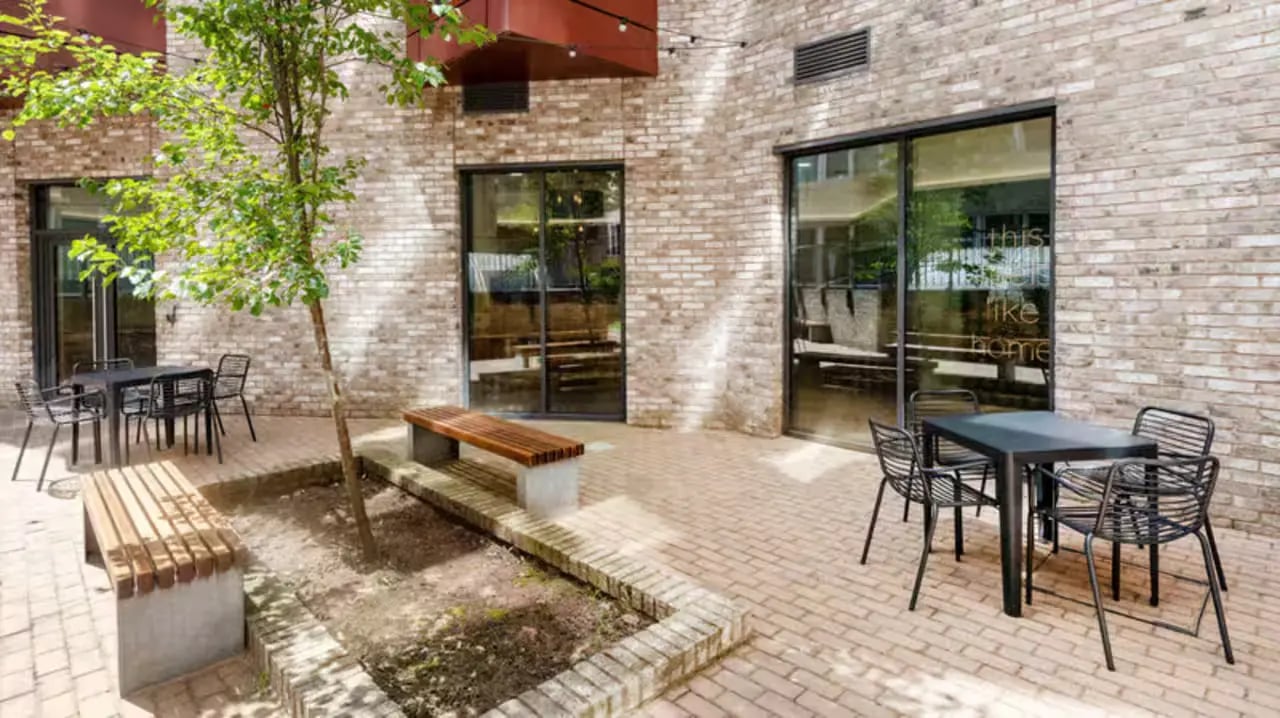 Tables chairs benches and a tree courtyard exterior at Fontenoy Apartments in Liverpool Student Accommodation