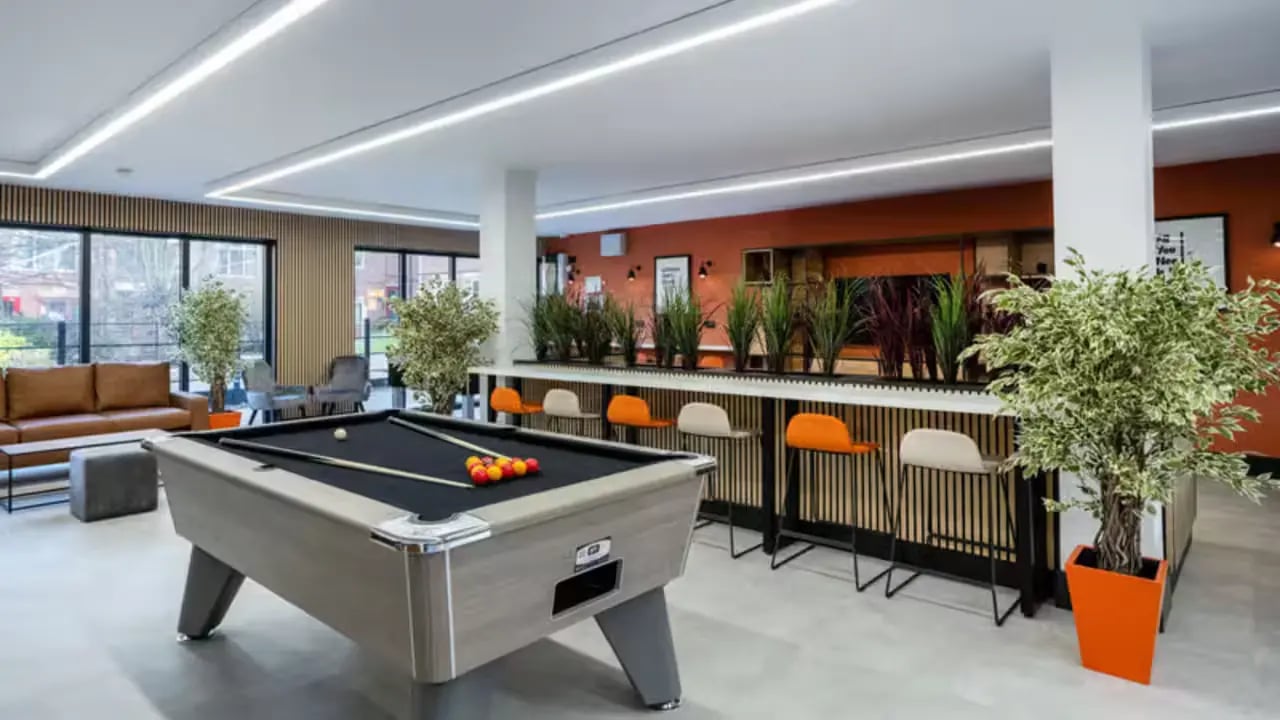 Pool table sofa bar stools plants living room at Paddington Park House in Liverpool Student Accommodation