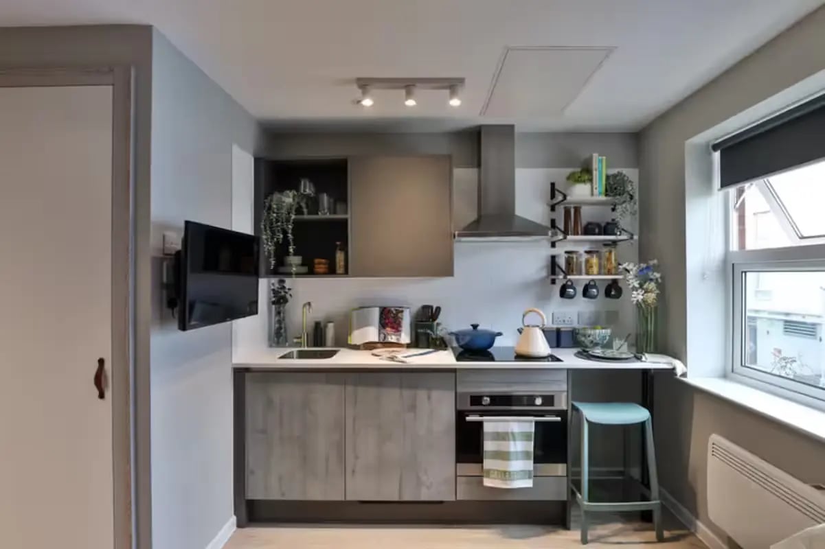 Modern grey kitchen with white counter and stool kitchen at Brook Studios in Birmingham Student Accommodation
