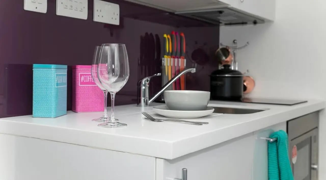 Wine glasses tins cutlery bowl sink kitchen at The Cube Ealing in London Student Accommodation