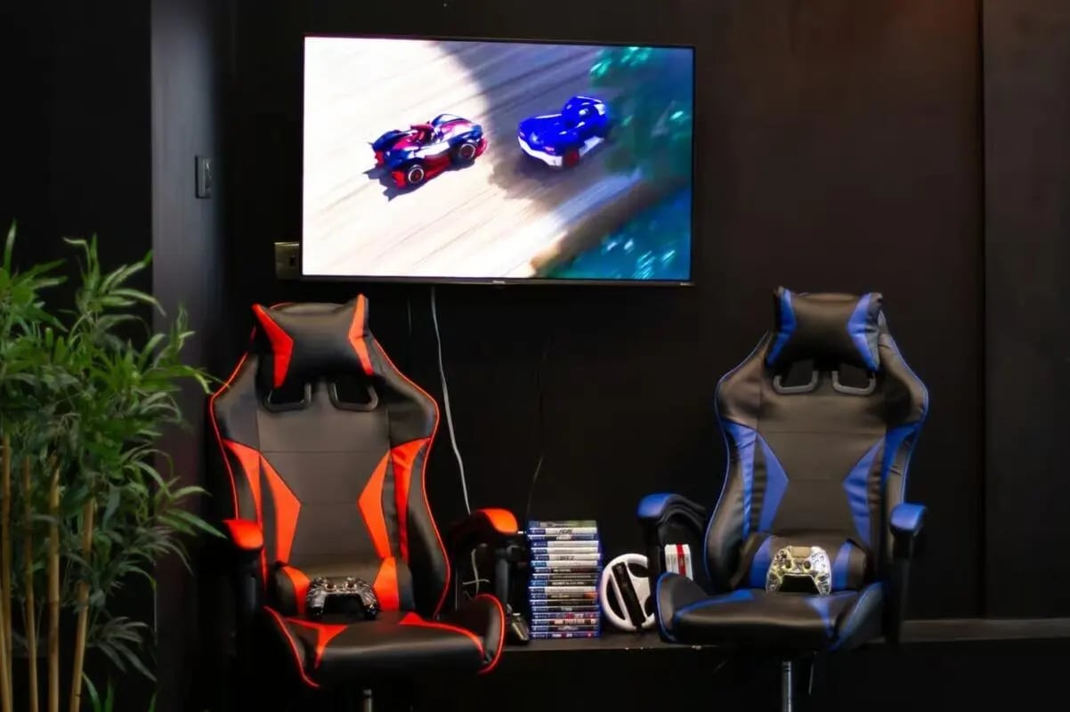 Gaming chairs controllers TV screen and games playing area at The Cube Ealing in London Student Accommodation