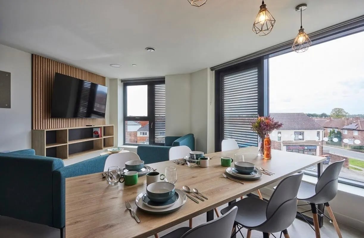 Dining table set for meal with seating area Living room at Regatta Place in Durham Student Accommodation