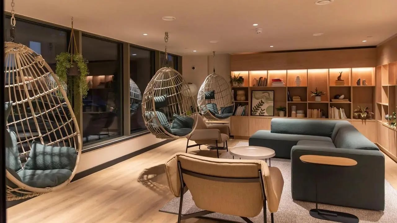 Hanging chairs modern sofa bookshelves living room at Centre Court in Nottingham Student Accommodation