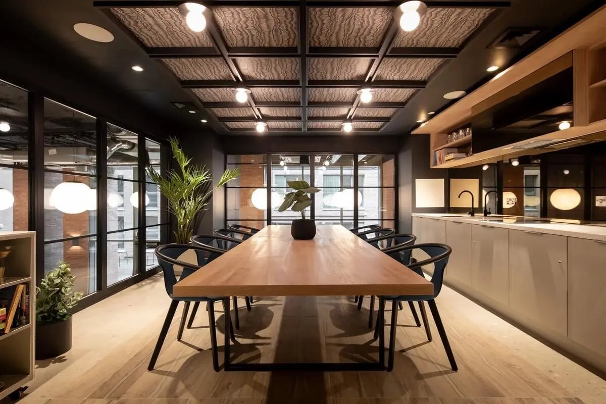 Long wooden table chairs plants kitchen communal area at Centre Court in Nottingham Student Accommodation