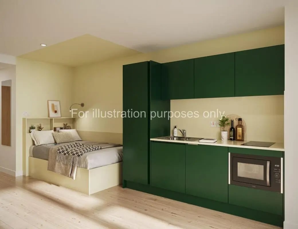 Bed and kitchen with green cabinets studio apartment at St Vincent Studios in Glasgow Student Accommodation