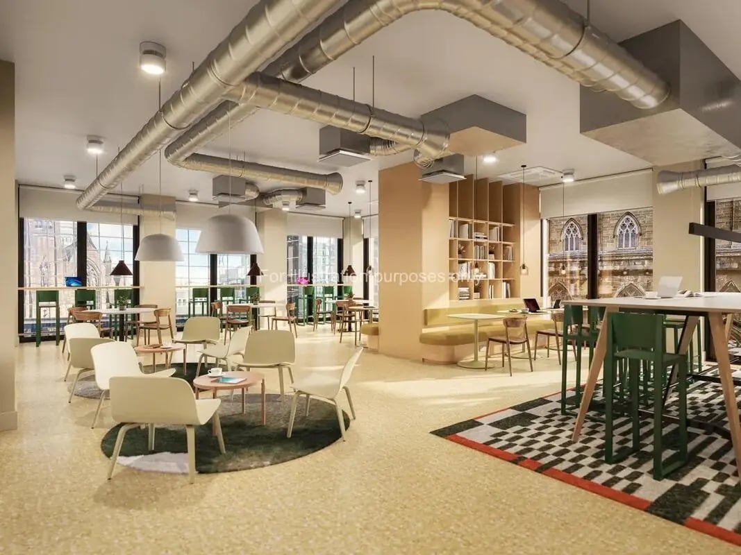 Modern common area with tables chairs and bookshelves. at St Vincent Studios in Glasgow Student Accommodation