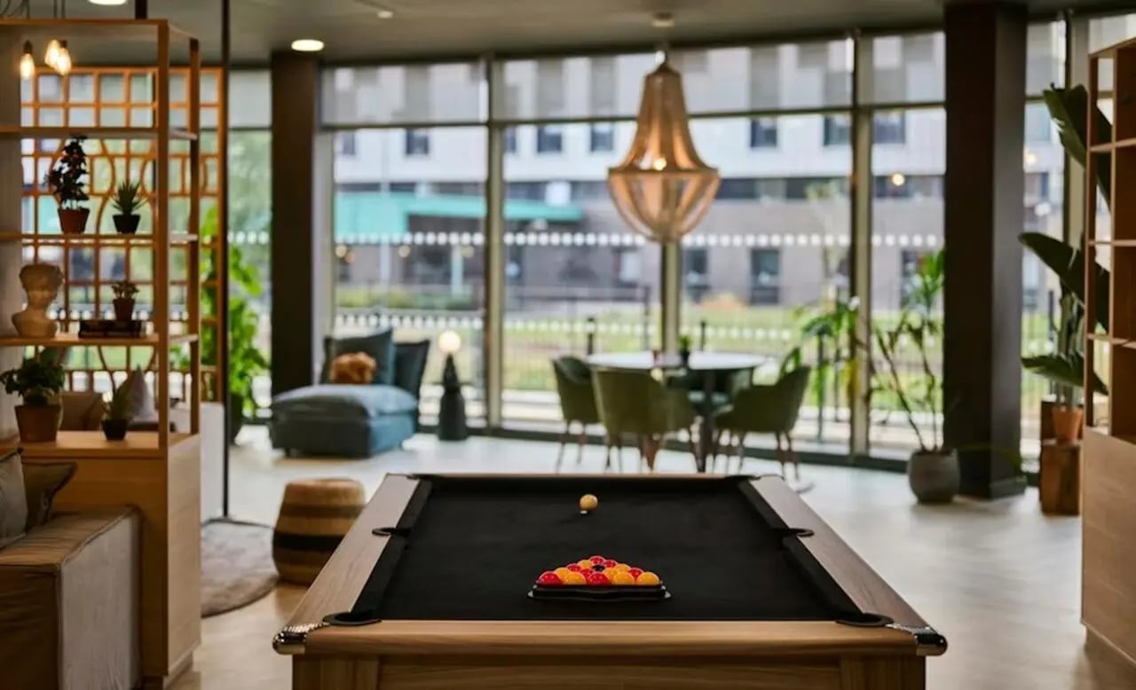 Pool table sofa chairs and plants common area at Deakins Place in Nottingham Student Accommodation