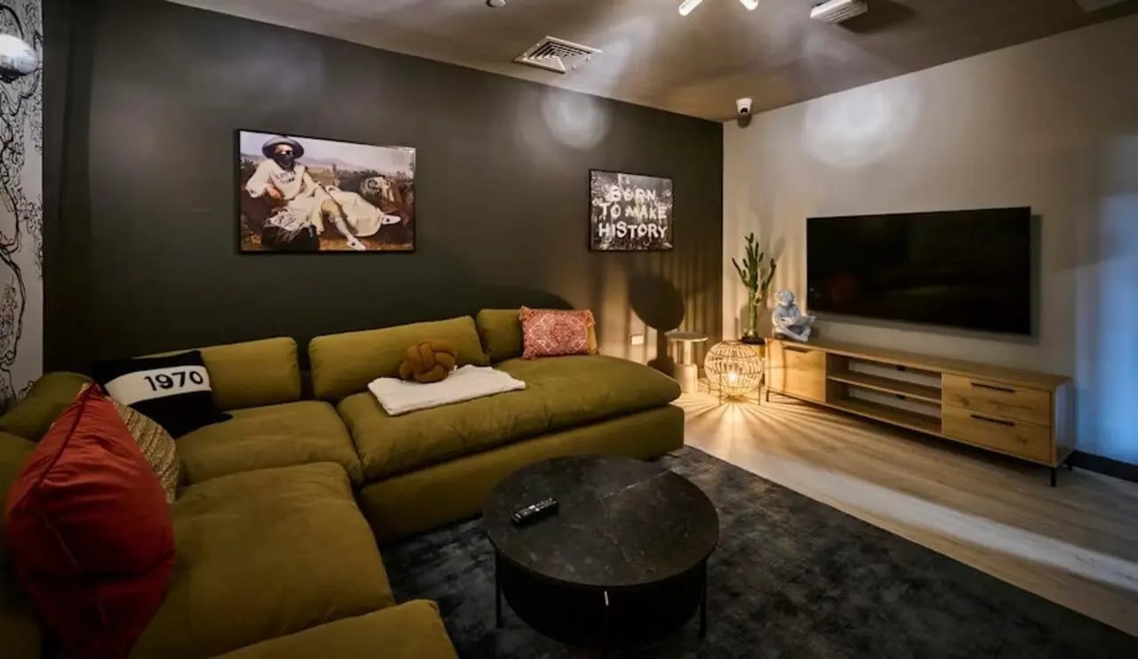 Large sectional sofa coffee table artwork and TV living room at Deakins Place in Nottingham Student Accommodation