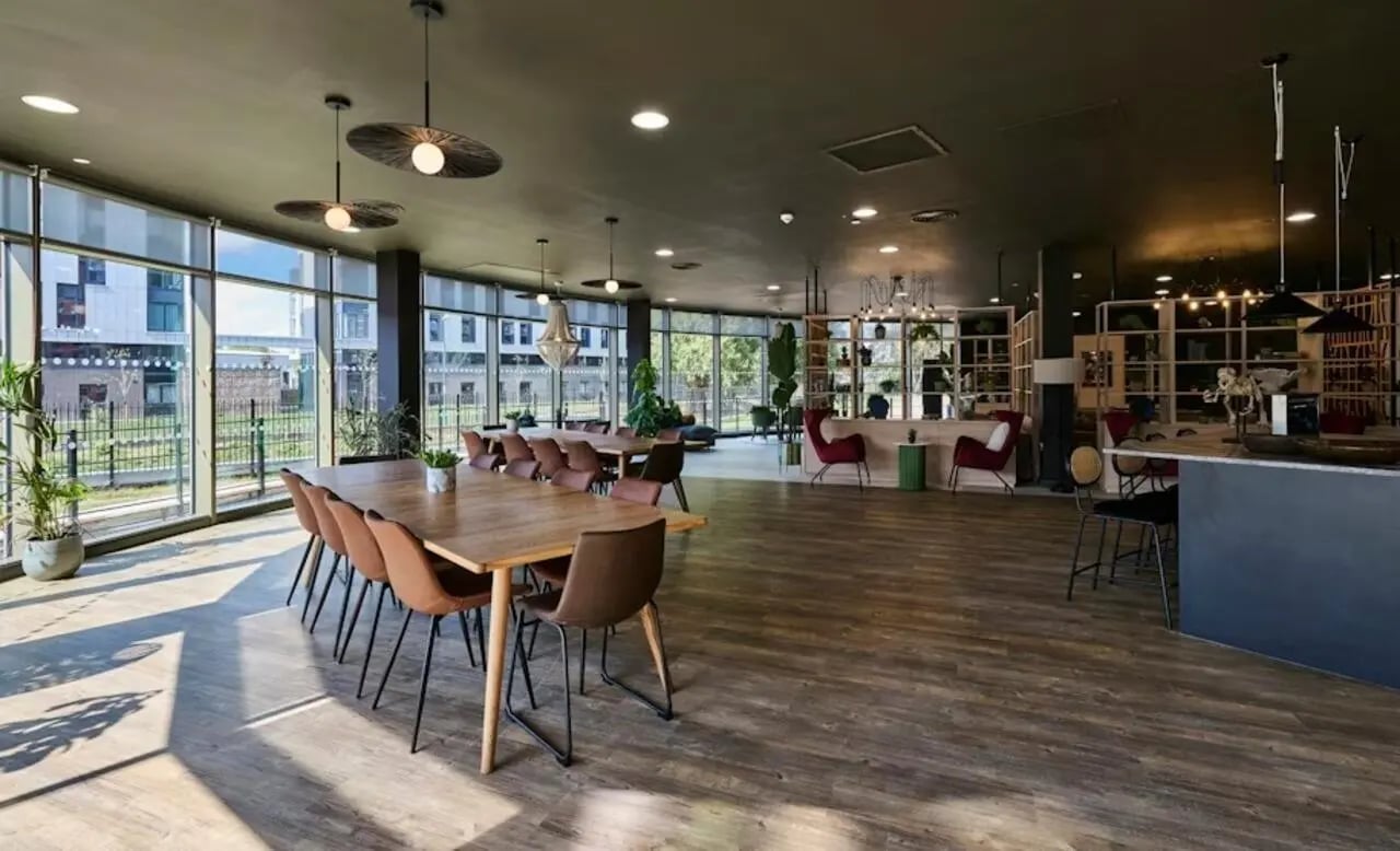 Communal dining tables chairs and lounge seating living room at Deakins Place in Nottingham Student Accommodation