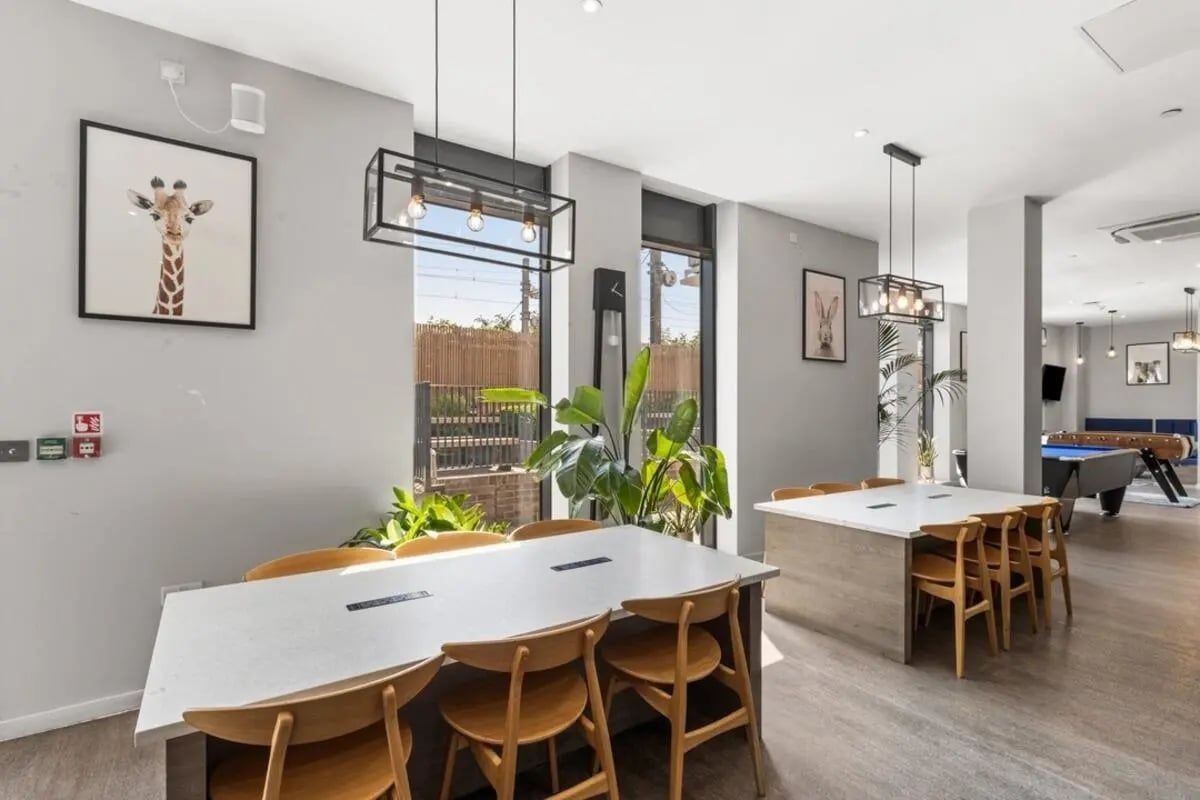Dining tables with chairs and pool table lounge at Canvas Walthamstow in London Student Accommodation