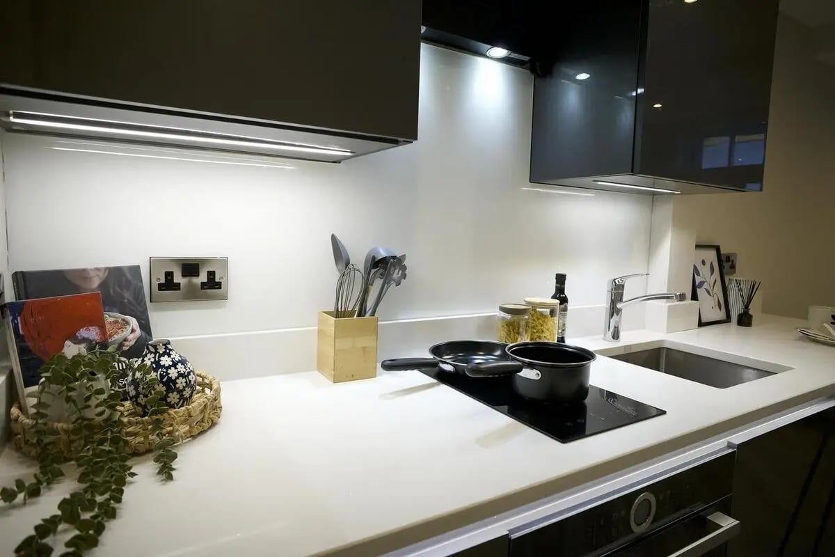Countertop with utensils pots and sink kitchen at dwell 121 Princess Street in Manchester Student Accommodation