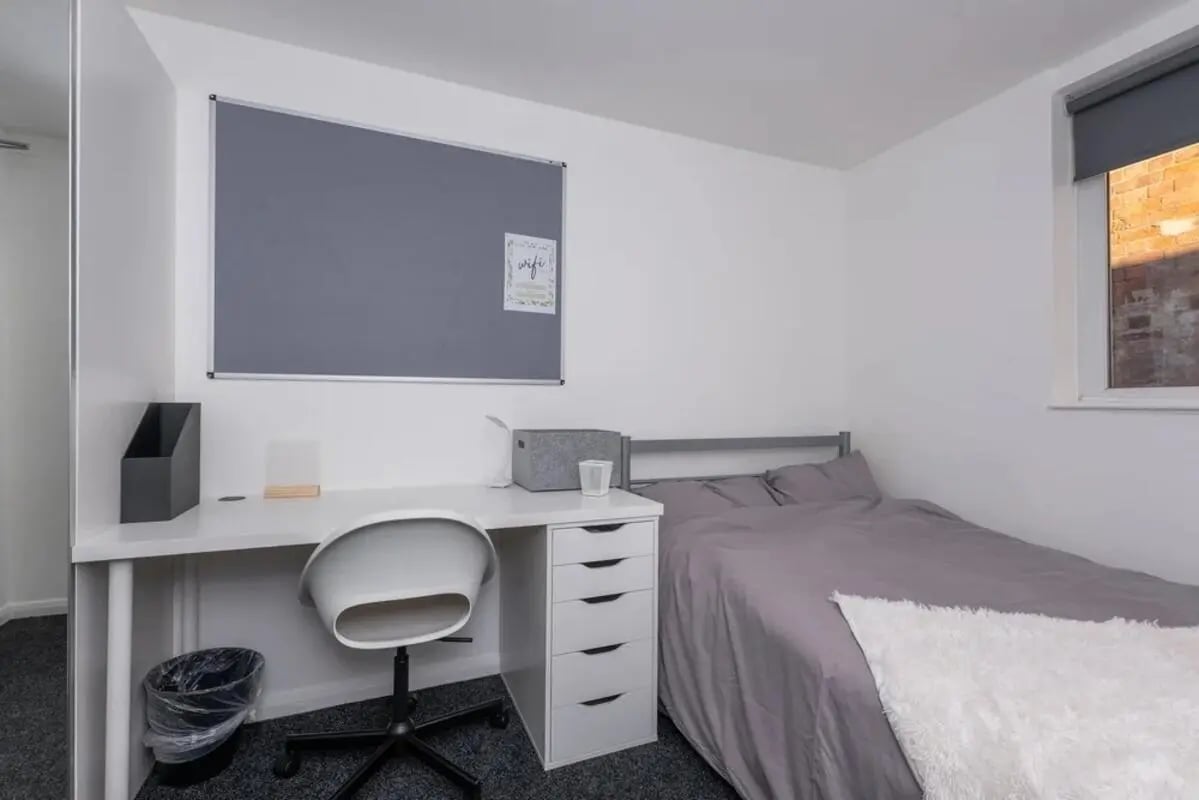 Desk chair bed and bulletin board bedroom at Bertrand Russell House in Nottingham Student Accommodation