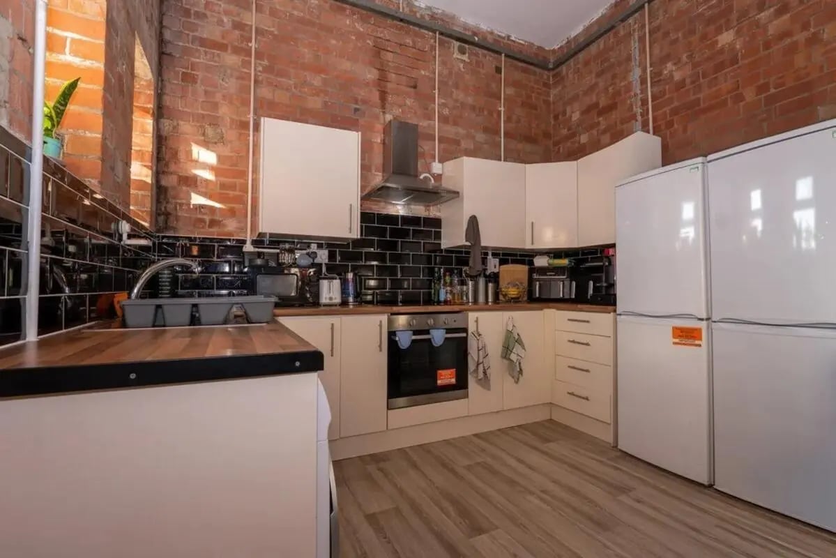 Brick kitchen with white cabinets and appliances kitchen at Bertrand Russell House in Nottingham Student Accommodation