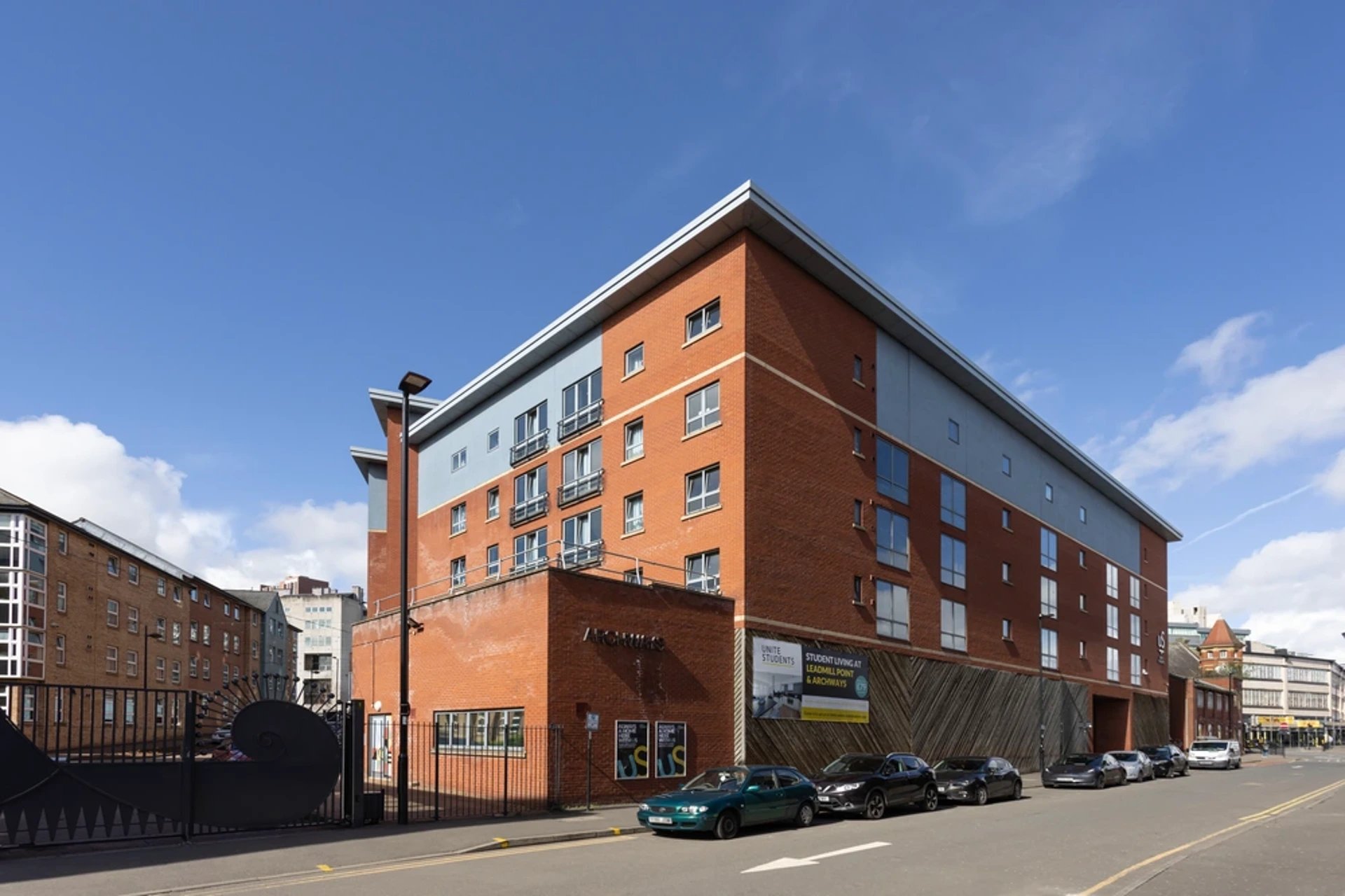 Modern brick building with cars parked outside exterior at Archways in Sheffield Student Accommodation