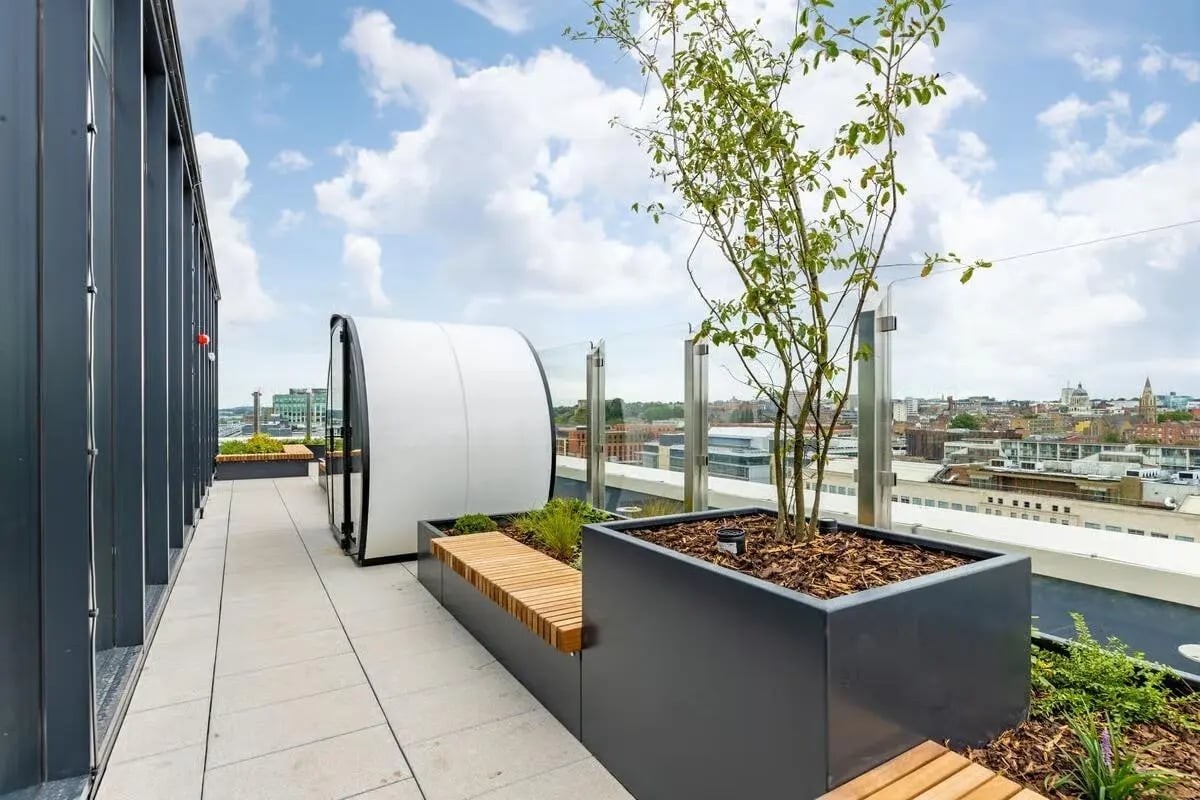 White pod building wooden benches plant boxes exterior at The Place in Nottingham Student Accommodation