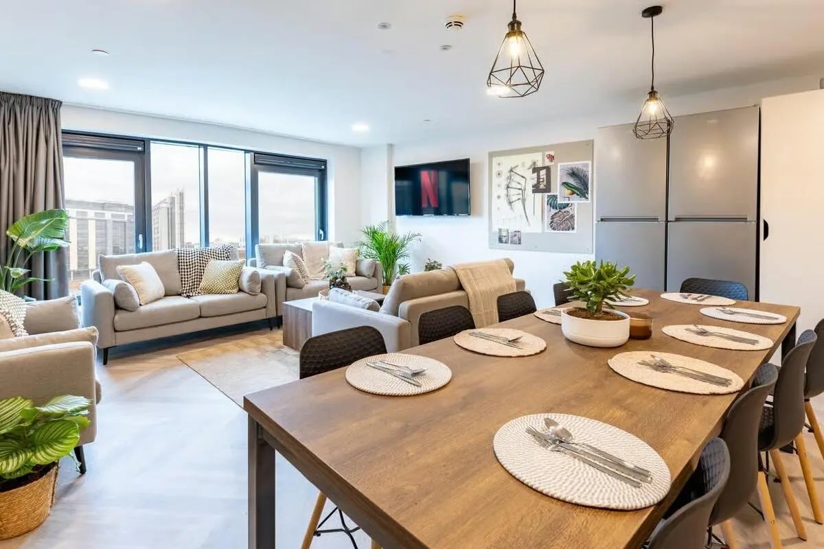 Dining table with place settings and sofas living area at The Place in Nottingham Student Accommodation