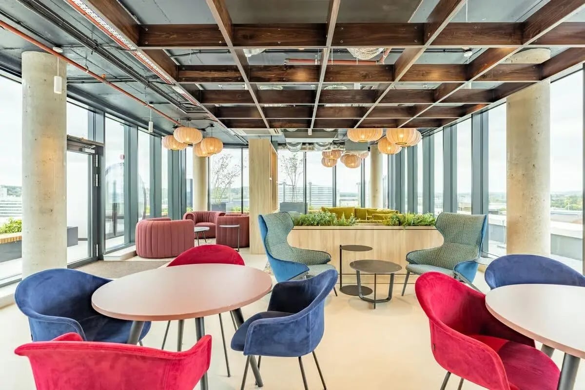 Round tables red blue chairs lounge area living room at The Place in Nottingham Student Accommodation