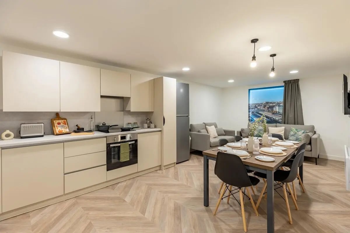 Modern kitchen and living area with dining table and sofas Living room at The Place in Nottingham Student Accommodation