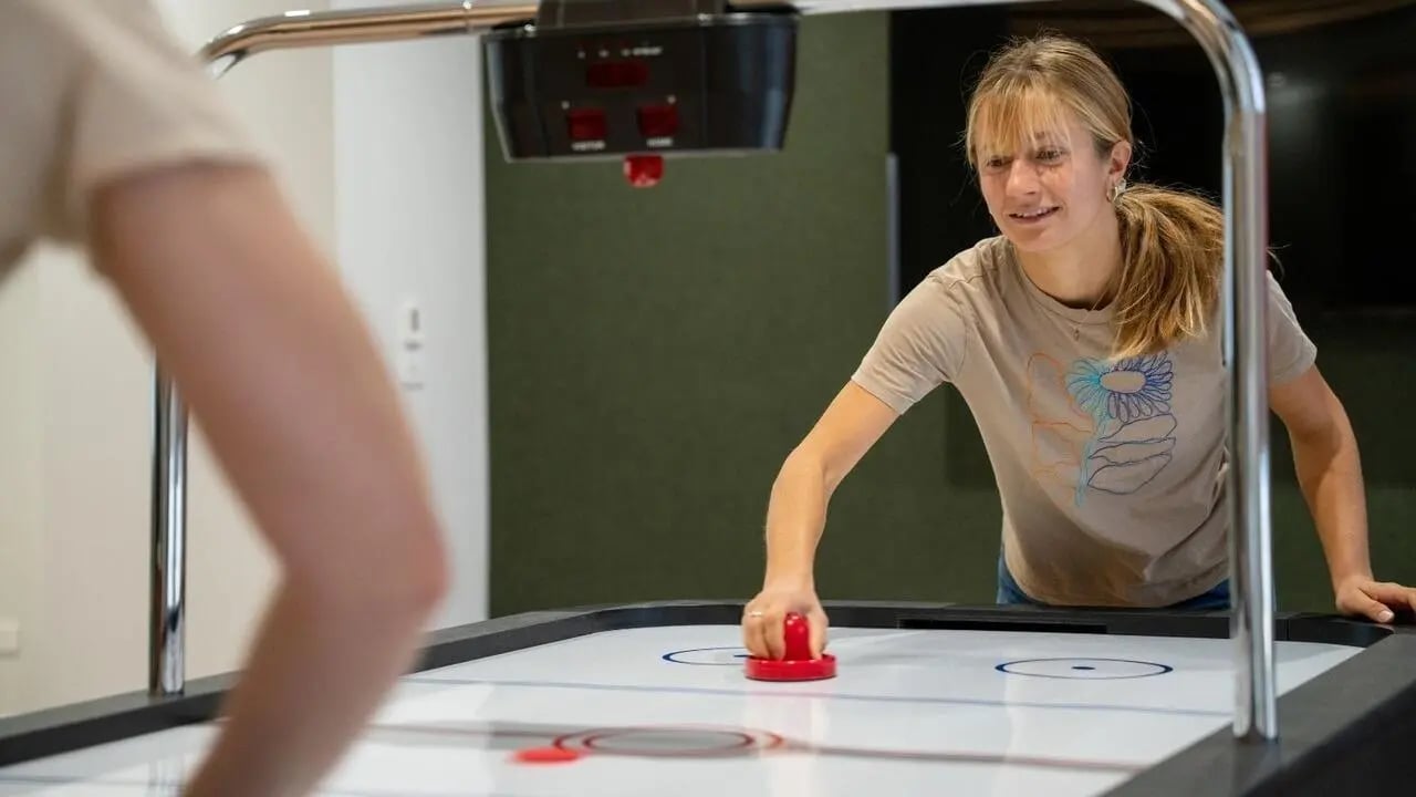 Students play air hockey in common area playing area at UniLodge Auckland Central in Auckland Student Accommodation