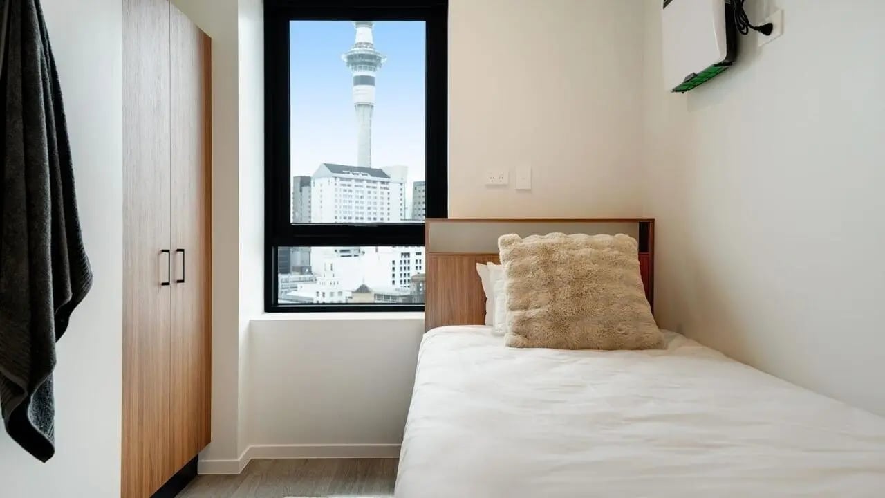 Wooden wardrobe white bed fluffy pillow bedroom at UniLodge Auckland Central in Auckland Student Accommodation