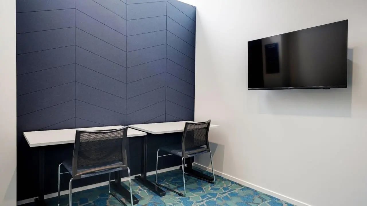 Two desks chairs wall mounted TV study area at UniLodge Auckland Central in Auckland Student Accommodation