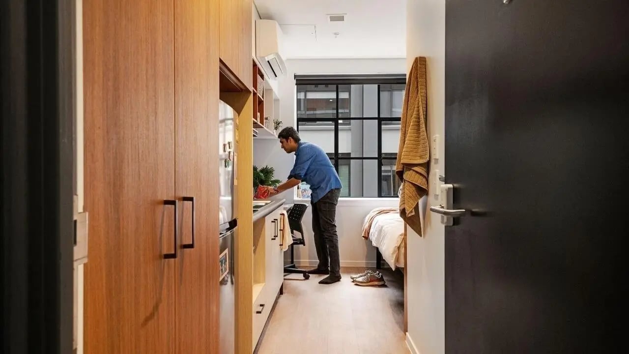 Student preparing food in studio apartment bedroom at UniLodge Auckland Central in Auckland Student Accommodation