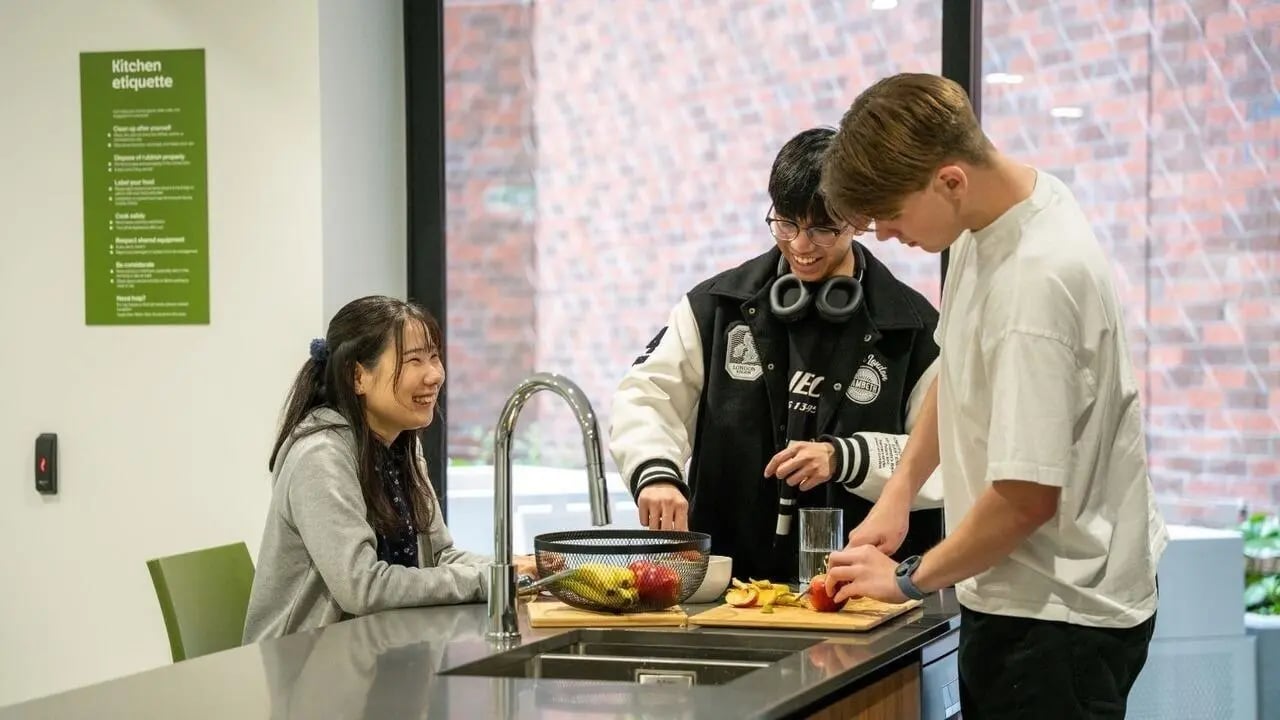 Students preparing food in a communal kitchen. at UniLodge Auckland Central in Auckland Student Accommodation