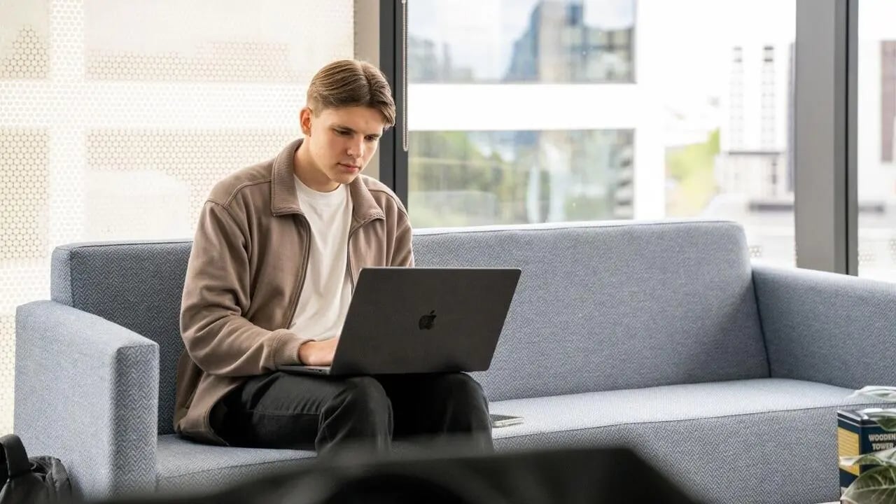 Man on sofa with laptop study area at UniLodge Auckland Central in Auckland Student Accommodation