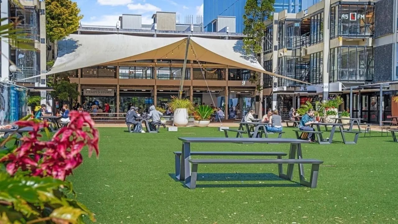 Campus store building with people dining outside exterior at UniLodge Auckland Central in Auckland Student Accommodation